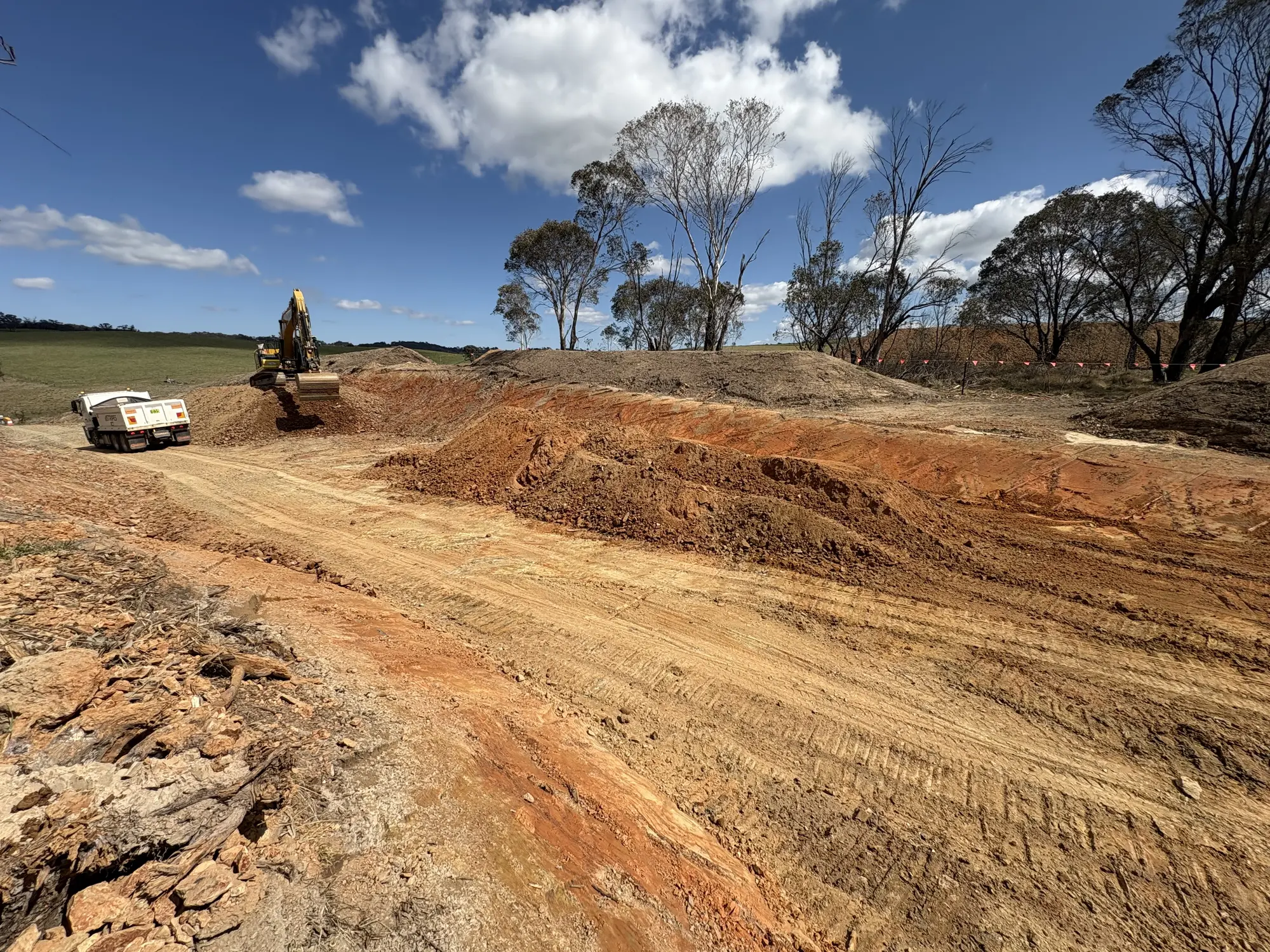 Excavator completing earthworks beside Rockvale Road in the Armidale region