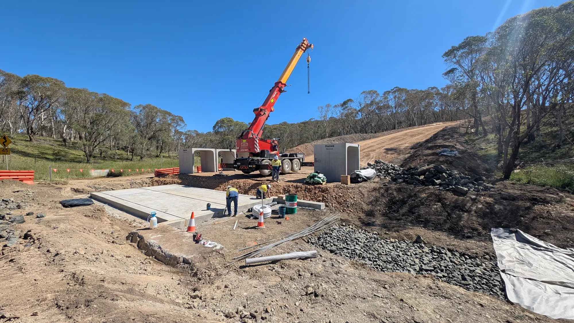 Crane and construction crews installing upgraded culverts beneath Rockvale Road